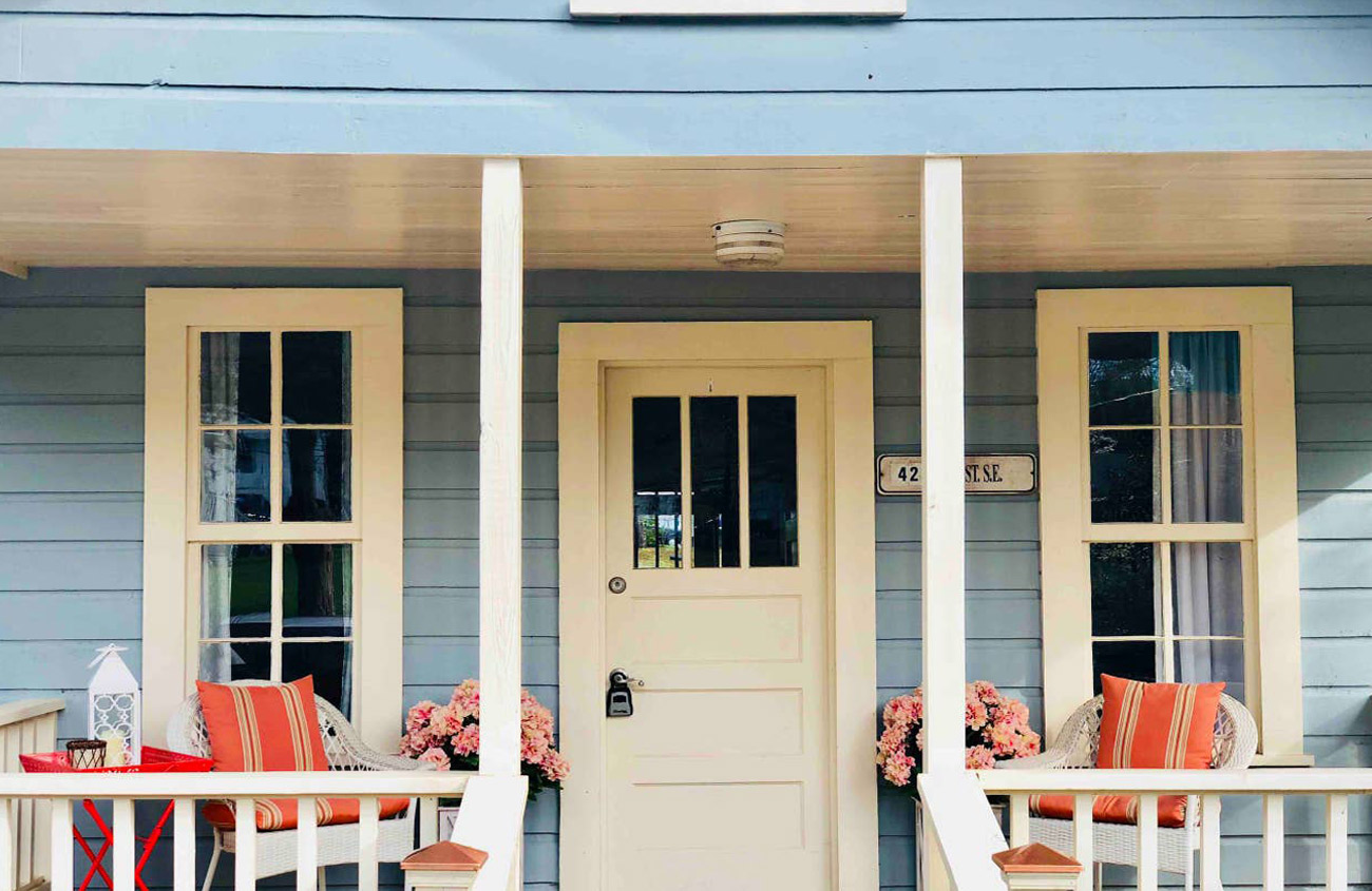 Bright blue cottage with cream door and pink flowers