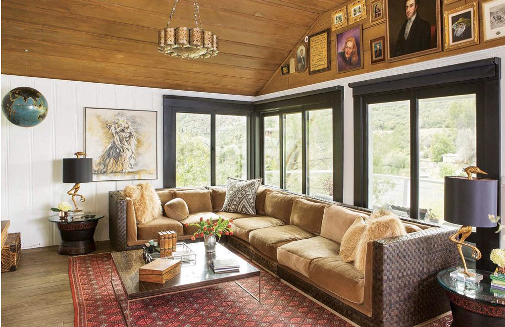 Living room with a wall of light spilling windows and a large sectional couch.