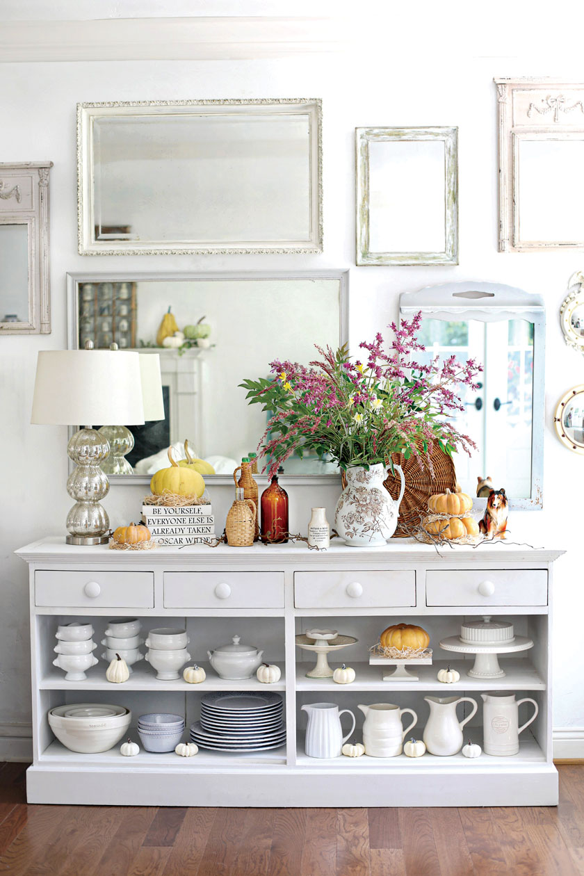 sideboard styled with white dish ware and pumpkins