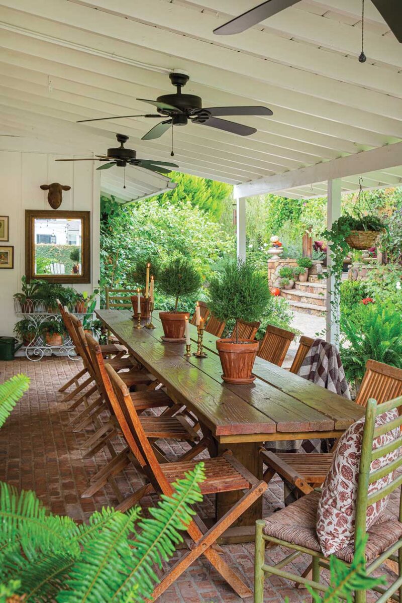 wooden dining table and ceiling fans on covered patio in renovated California home