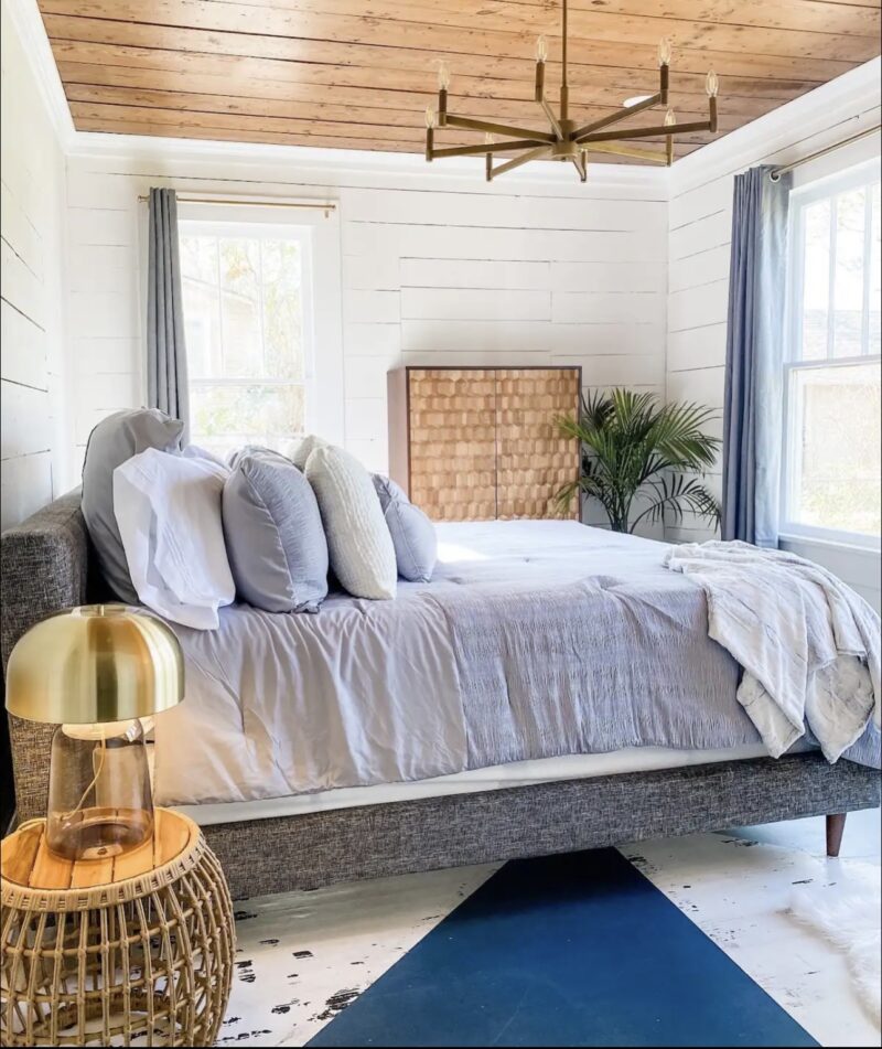 gray upholstered bedframe and wood accents in Cottage on Fort bedroom