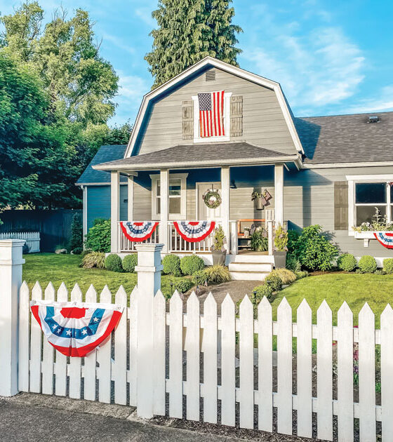 gambrel home with patriotic flags