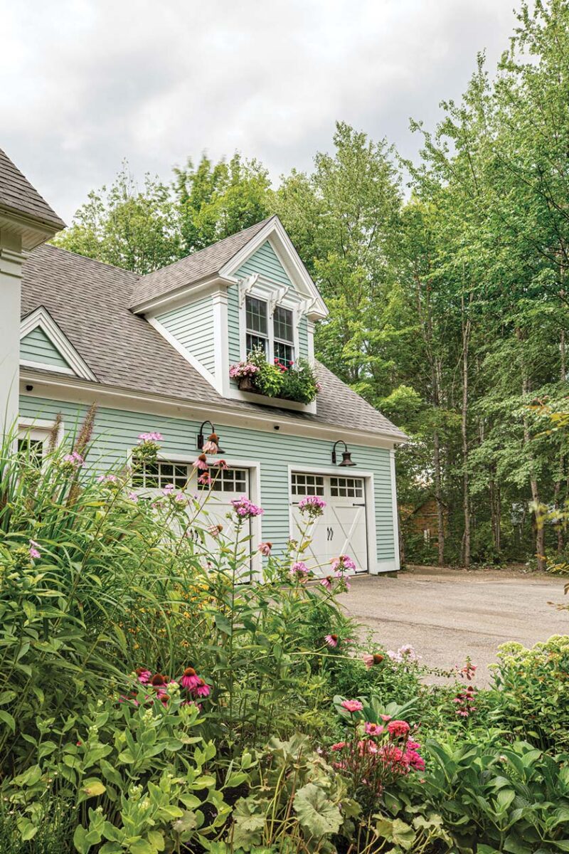 green siding and white trim with flowers in exterior of Maine home